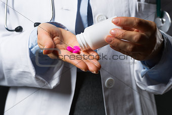 Closeup on medical doctor woman empty medicine bottle in hand