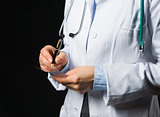 Closeup on medical doctor woman writing prescription on black ba