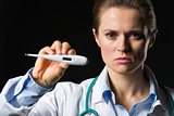 Medical doctor woman showing thermometer isolated on black