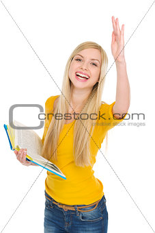 Happy student girl with book rising hand to answer