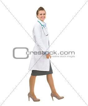 Full length portrait of medical doctor woman going sideways