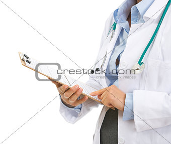Closeup on medical doctor woman checking clipboard