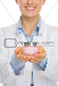 Closeup on kosmetist woman showing creme