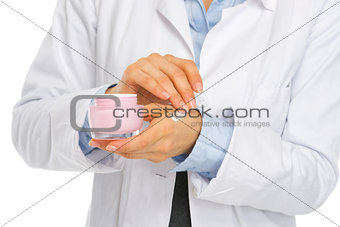 Closeup on kosmetist woman applying creme on hand