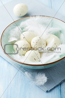 Bowl of easter eggs and feathers