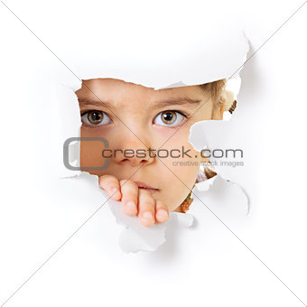 Child's face looking through a hole in paper