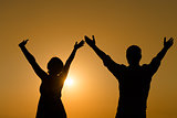 Loving couple raise their hands with enjoy at sunset