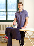 Attractive male ironing his shirt