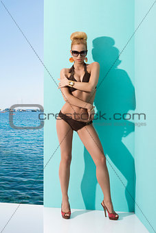 woman in bikini with sunglasses and hand on the arm