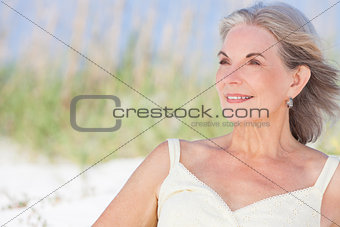 Attractive Senior Woman Sitting At Beach