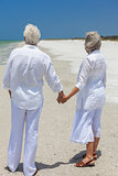 Happy Senior Couple Holding Hands on Tropical Beach