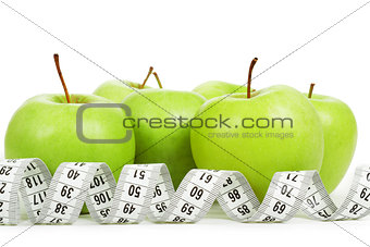 Measuring tape around a green apples as a symbol of diet.