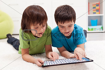 Boys playing labyrinth game on tablet computer