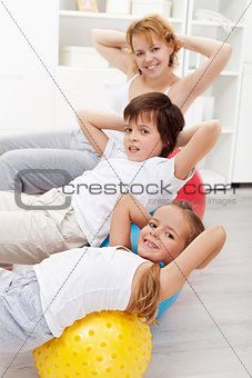Kids with their mother doing gymnastic exercises