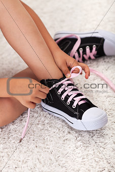 Child hands tie shoelaces