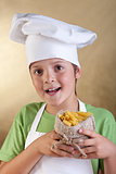 Happy boy with chef hat holding raw pasta in small sack