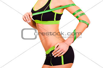 Slim figure of girl is in a sportwear with a centimetre ribbon on a hand