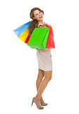 Full length portrait of smiling young woman with shopping bags