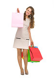 Full length portrait of happy young woman showing shopping bags