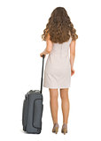 Woman with wheels suitcase. Rear view
