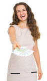 Smiling young woman giving fun of euro banknotes