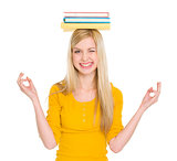 Student girl in yoga pose with books on head