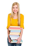 Happy student girl holding pile of books