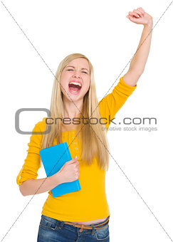 Happy student girl with book rejoicing success