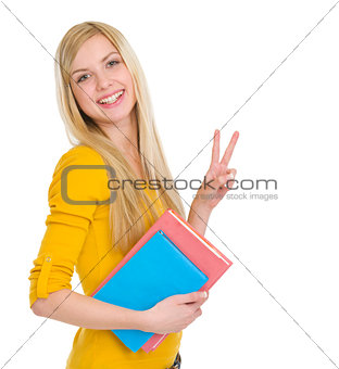 Happy student girl showing victory gesture