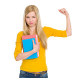 Happy student girl with book showing biceps