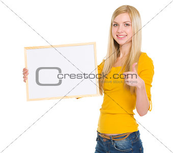 Happy student girl showing blank board and thumbs up
