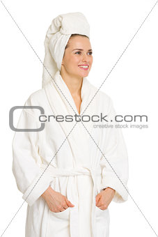 Happy young woman in bathrobe looking on copy space