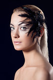 girl with feathered accessory, she looks in to the lens