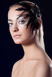 girl with feathered accessory and serious expression