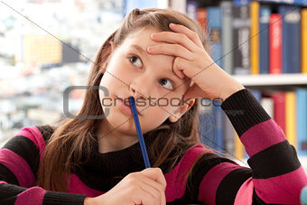 Girl thinking while doing homework