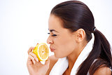 Woman holding lemon while making a face