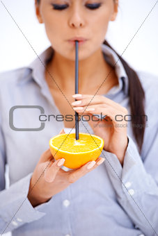 Woman drinks orange juice through a straw