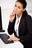 Woman in black suit sitting in front of computer