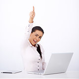Happy woman sitting at her desk, with one arm rised