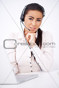 Business woman with headset sitting in front of laptop
