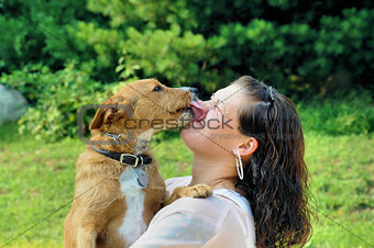 Young adult woman getting licked by her dog