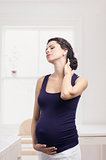 Pregnant woman standing with a pain in the neck