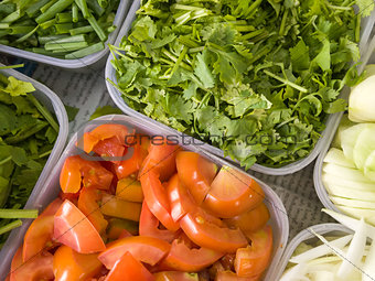 Coriander and tomatoes in a plastic tray