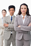 Businesswoman standing with team and folded arms