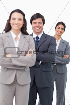 Smiling salesteam standing together with folded arms