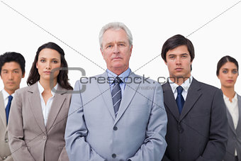 Mature businessman standing with his team