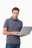 Young man standing with his laptop