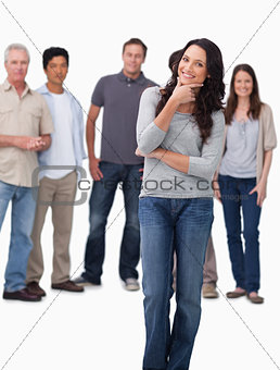 Woman in thinkers pose with friends behind her