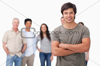 Young man with arms folded and friends behind him