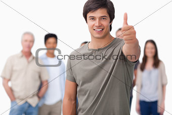 Smiling man with friends behind him giving approval
